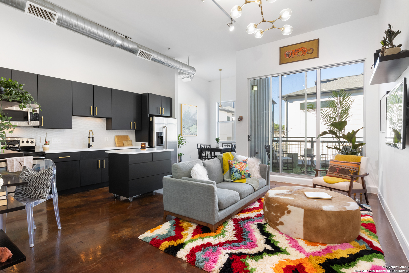 a living room with furniture kitchen and a chandelier