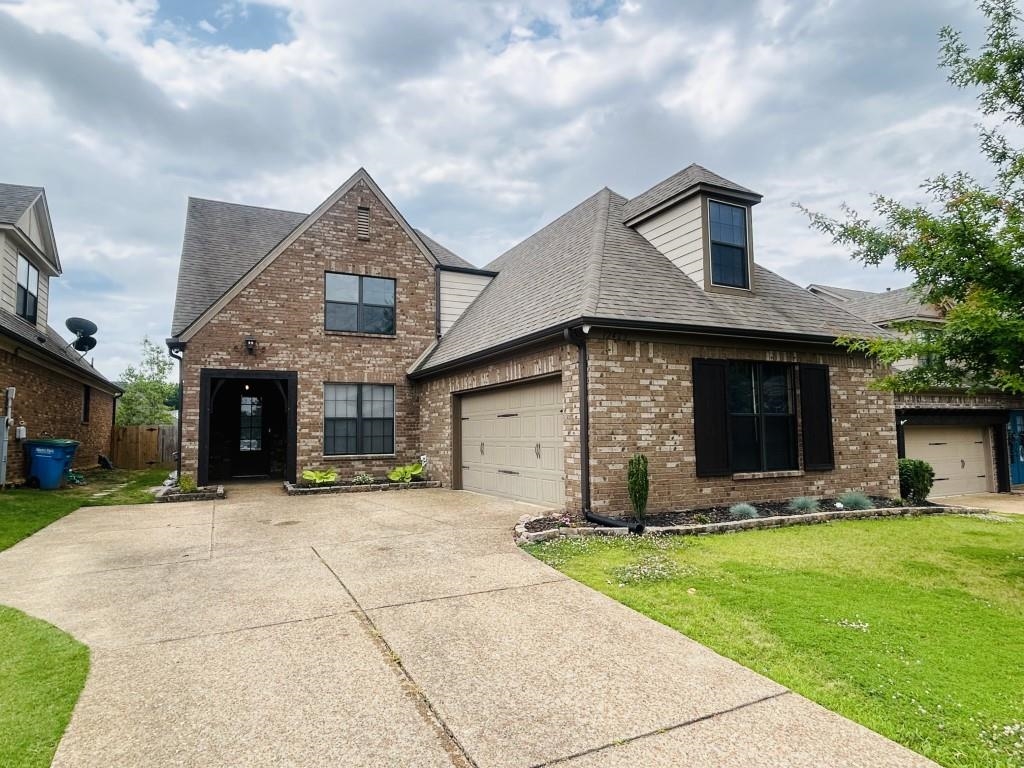 a front view of a house with a yard and garage