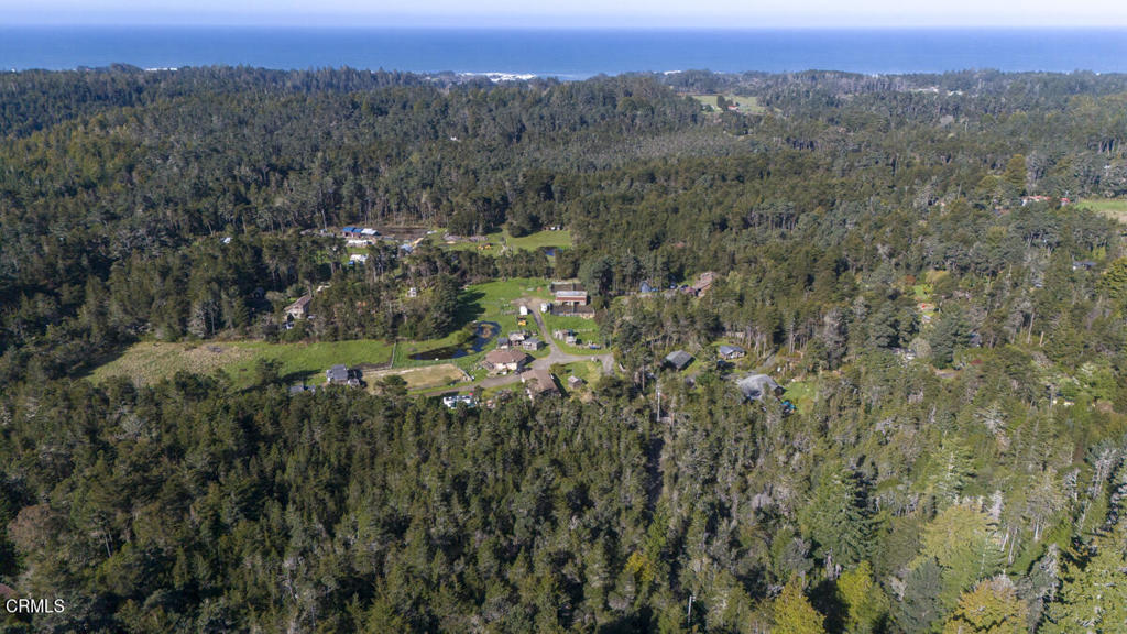 an aerial view of a city with lots of residential buildings and green landscape