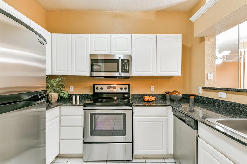 a kitchen with stainless steel appliances granite countertop a stove a microwave and a sink