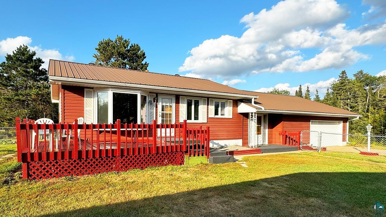 Back of property featuring a lawn and a deck