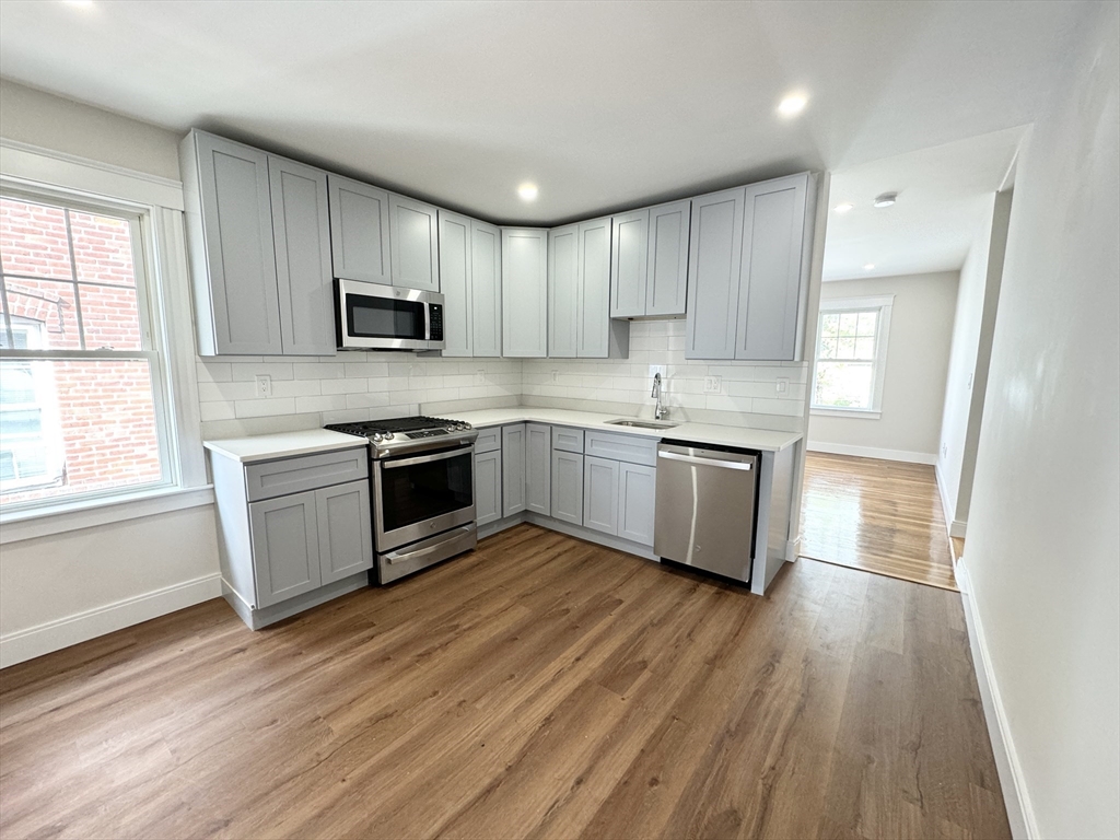 a kitchen with cabinets stainless steel appliances a sink and a window