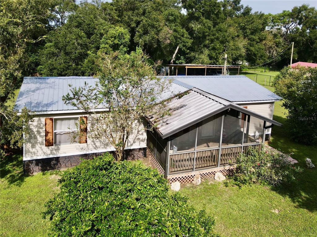 an aerial view of a house with a yard and a large tree