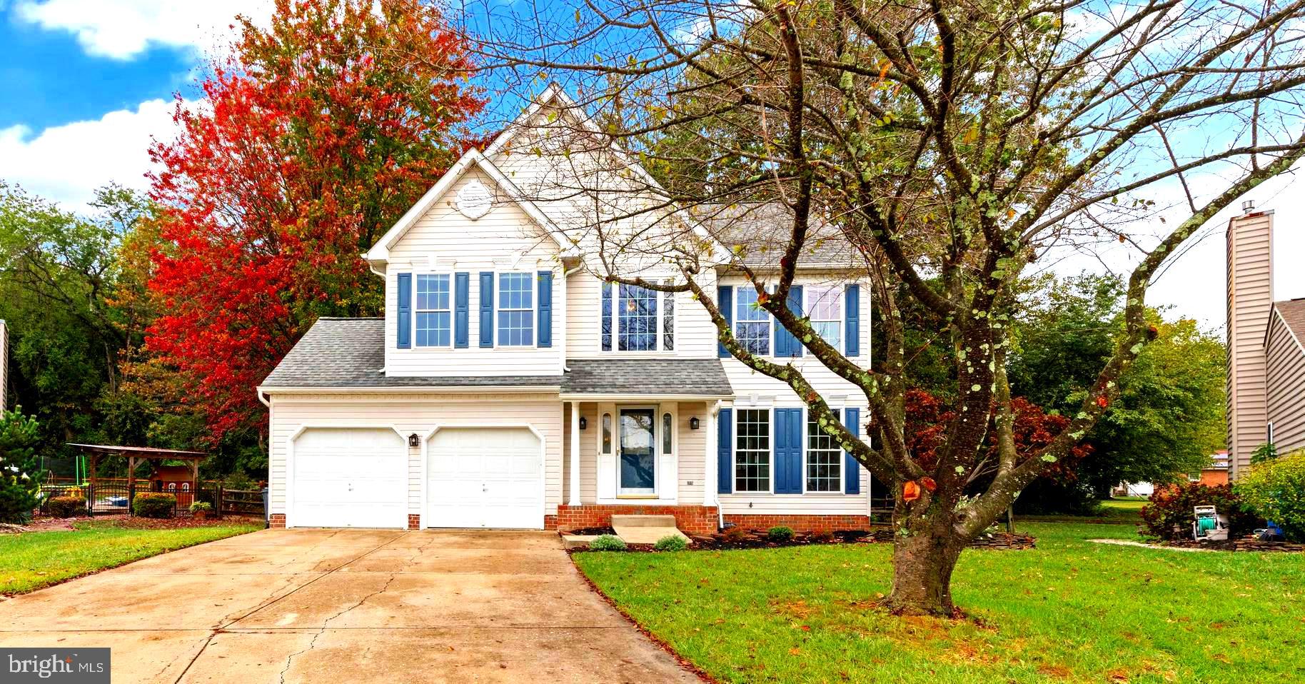 a front view of a house with a yard and trees