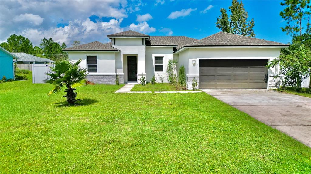 a front view of a house with a yard and garage