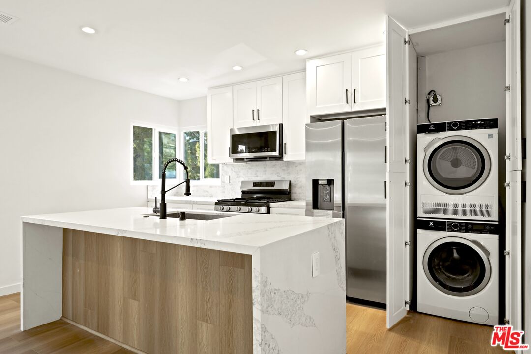 a kitchen with a sink a stove and cabinets