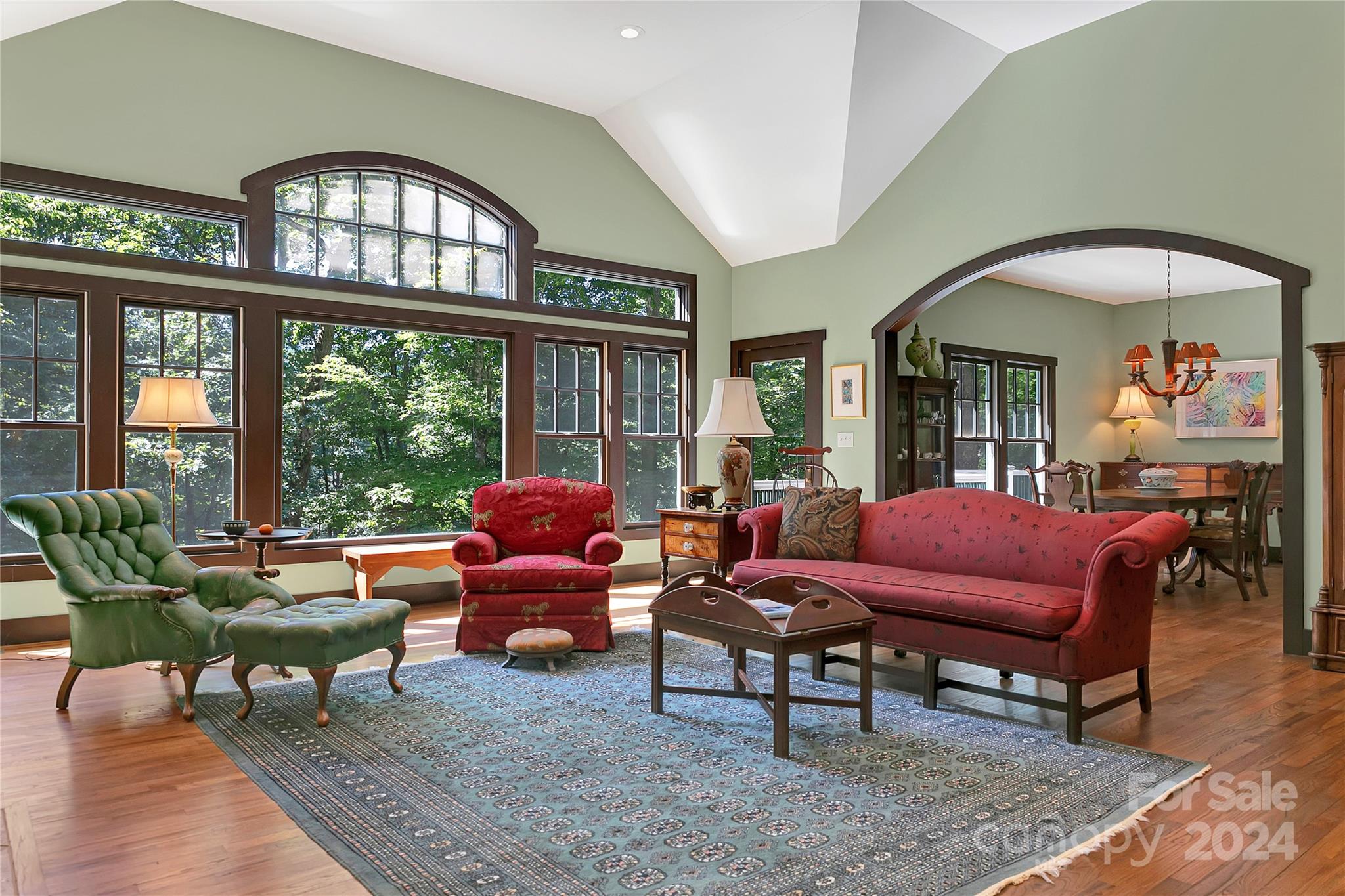 a living room with furniture a chandelier and a large window