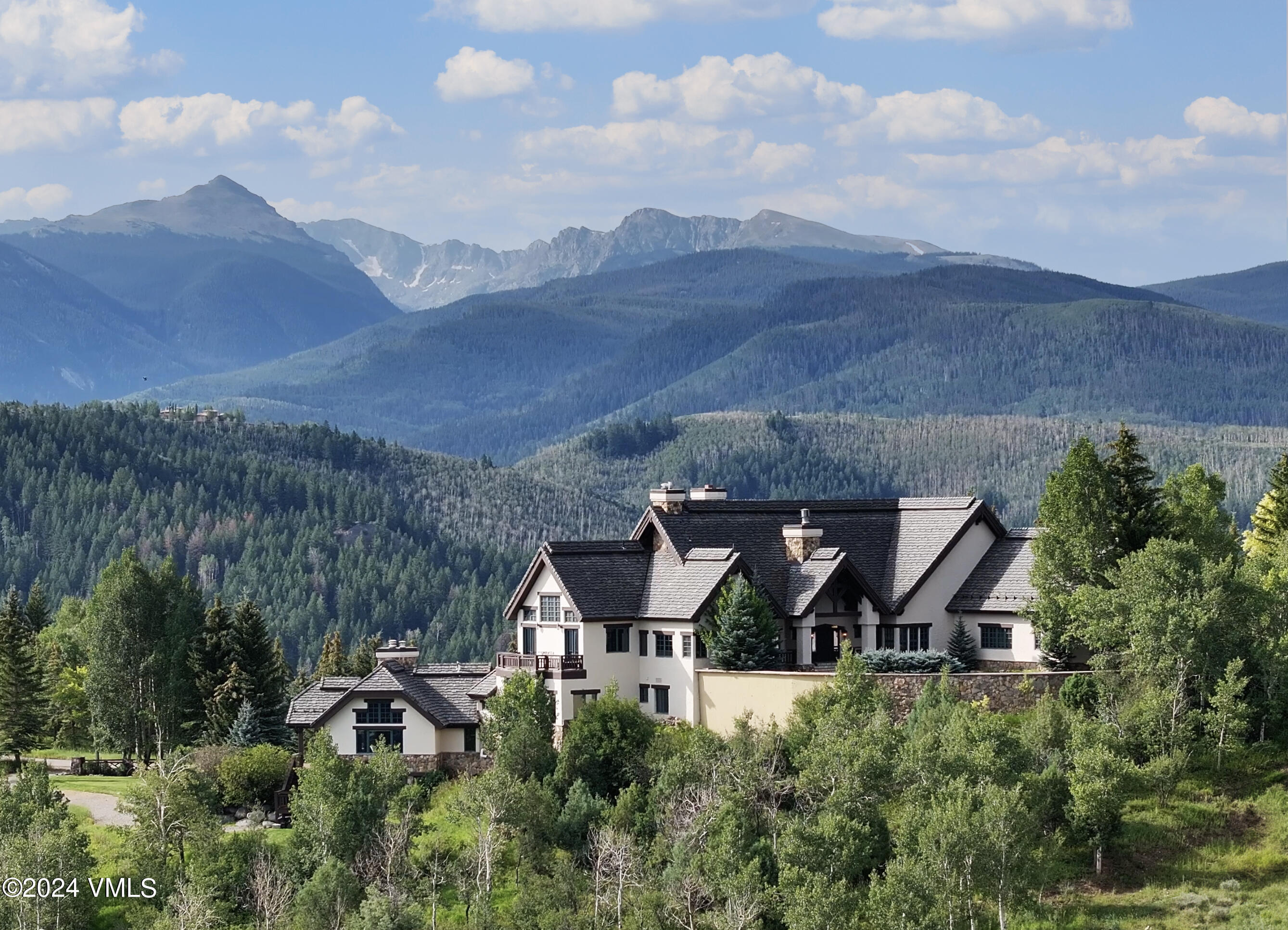 an aerial view of a house with a yard and mountain view