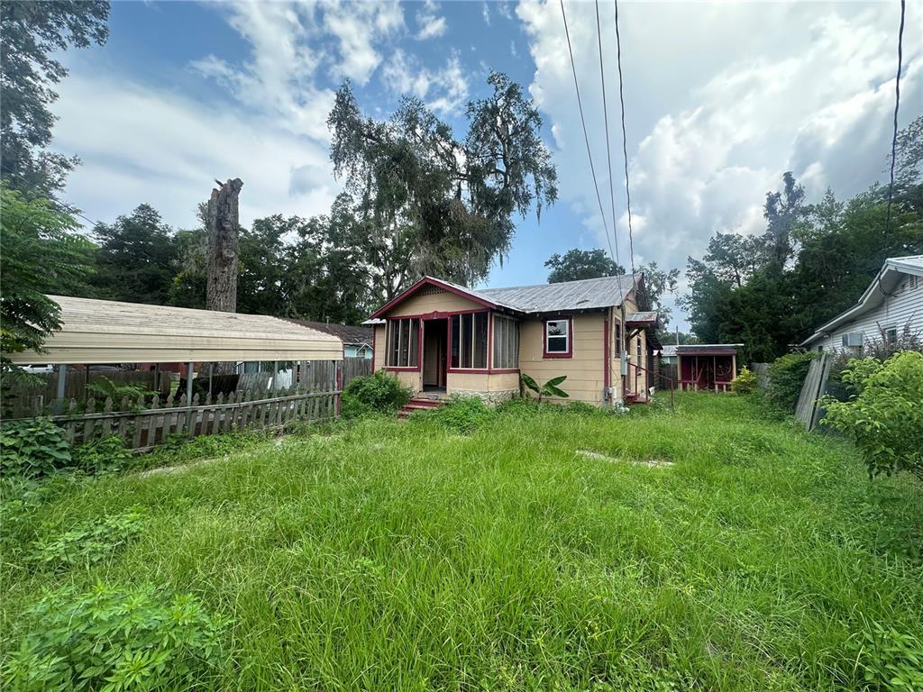 a view of a house with backyard and sitting area