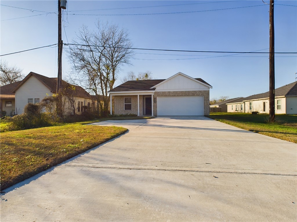 Ranch-style home with a garage and a front lawn