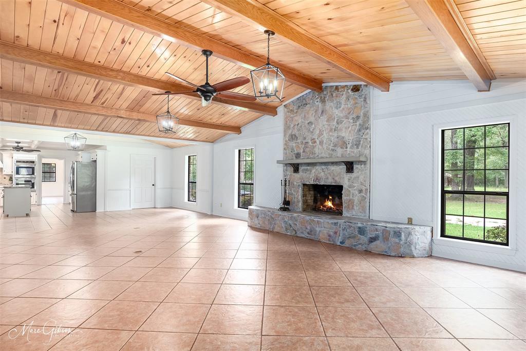 a view of an empty room with a fireplace and a window