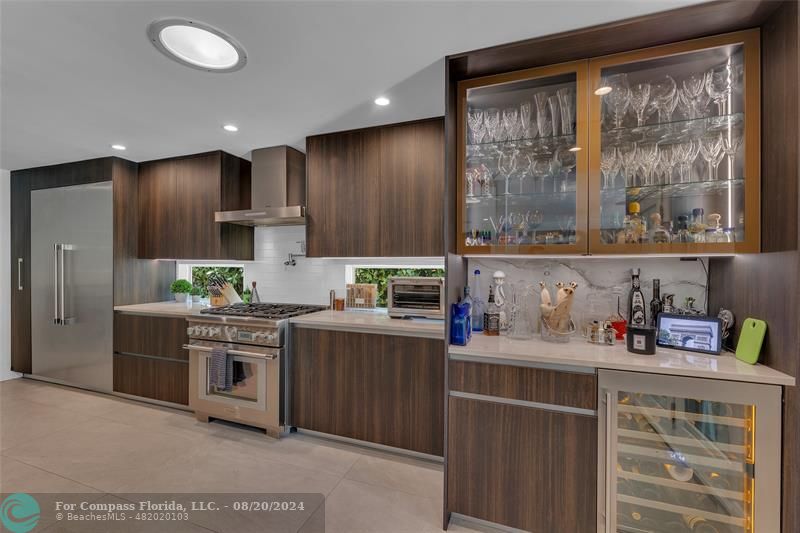 a kitchen with kitchen island granite countertop a sink cabinets and stainless steel appliances