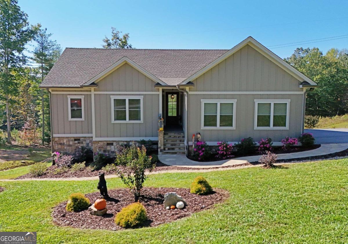 a front view of a house with yard and green space