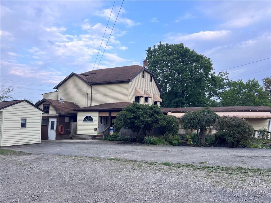 a view of a house with a yard and large tree