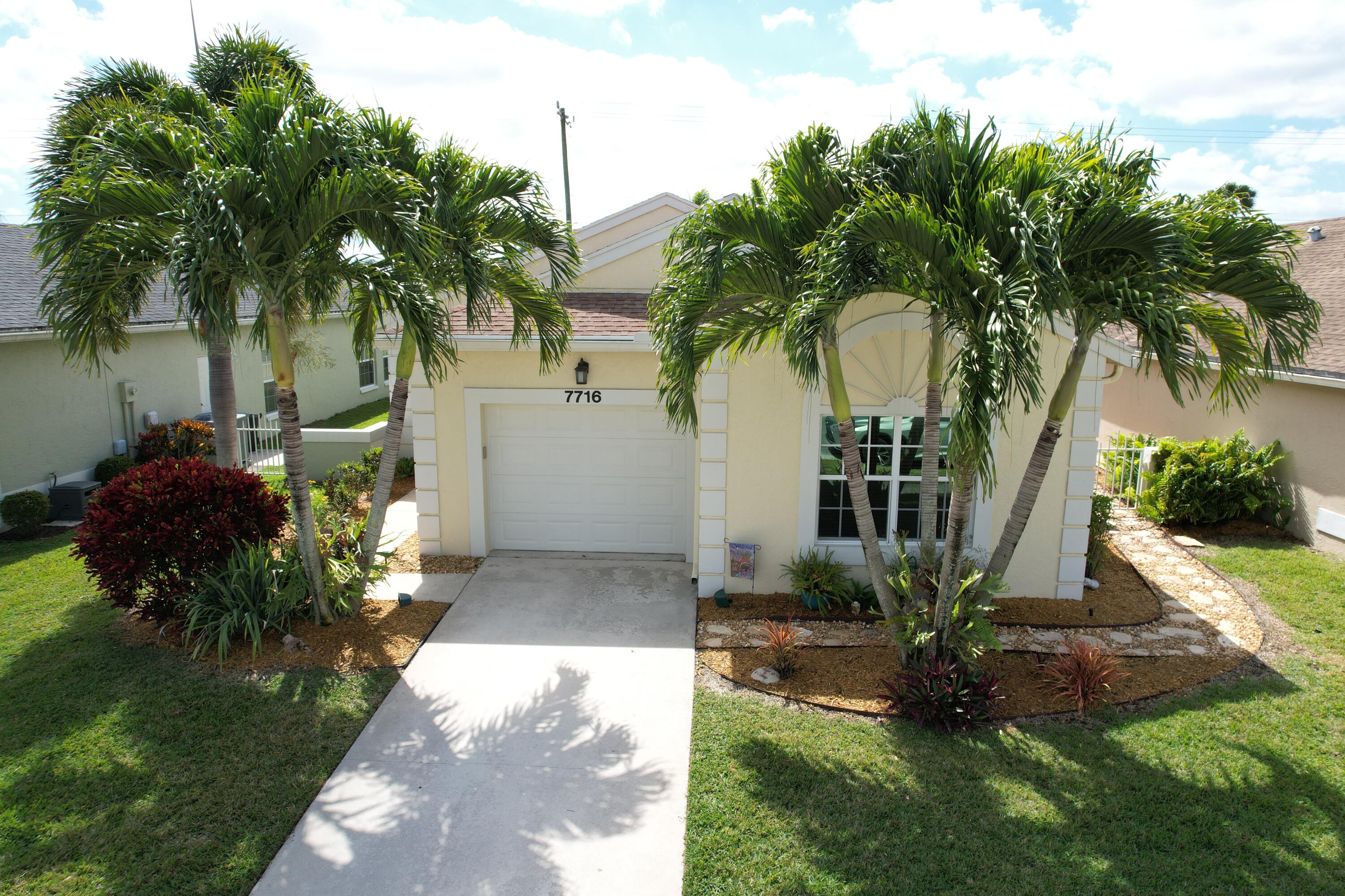 a view of a house with a yard and potted plants