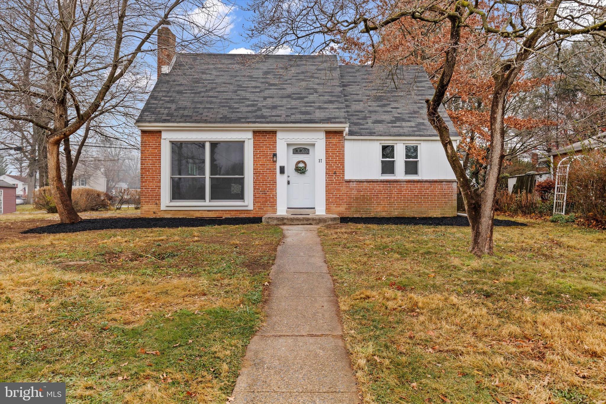 a front view of a house with a yard and trees