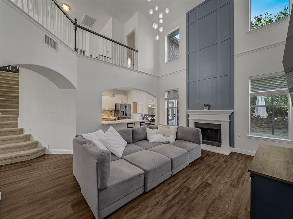 a living room with furniture a fireplace and a dining table with wooden floor