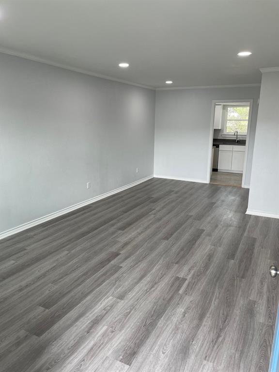 an empty room with wooden floor mirror and windows