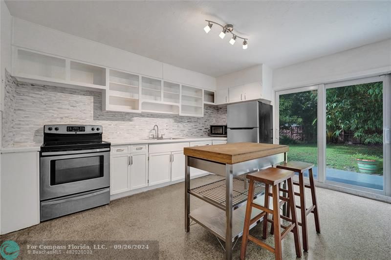 a kitchen with a stove a sink and a refrigerator