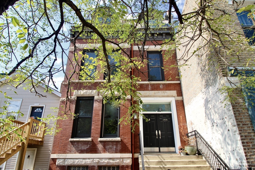 front view of a building with a tree