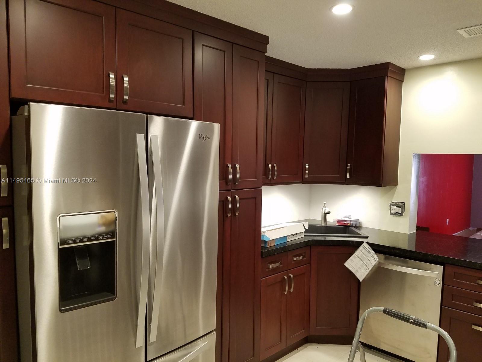 a kitchen with a refrigerator and a chair