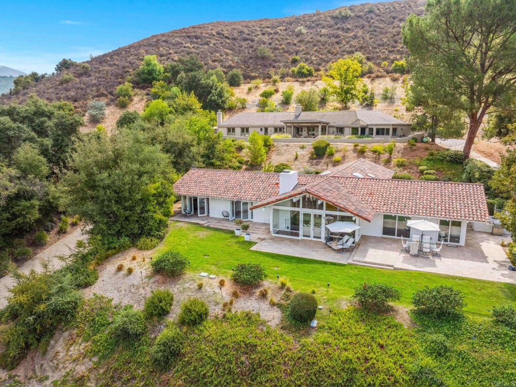 aerial view of a house with a big yard and large trees