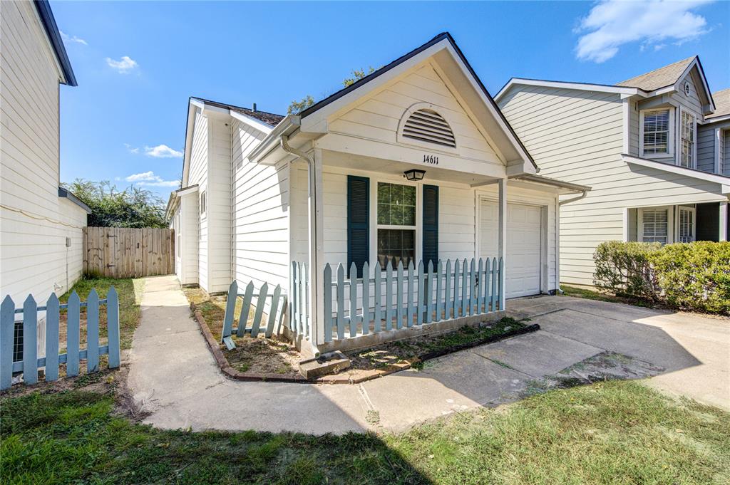 a view of a house with a small yard and wooden fence