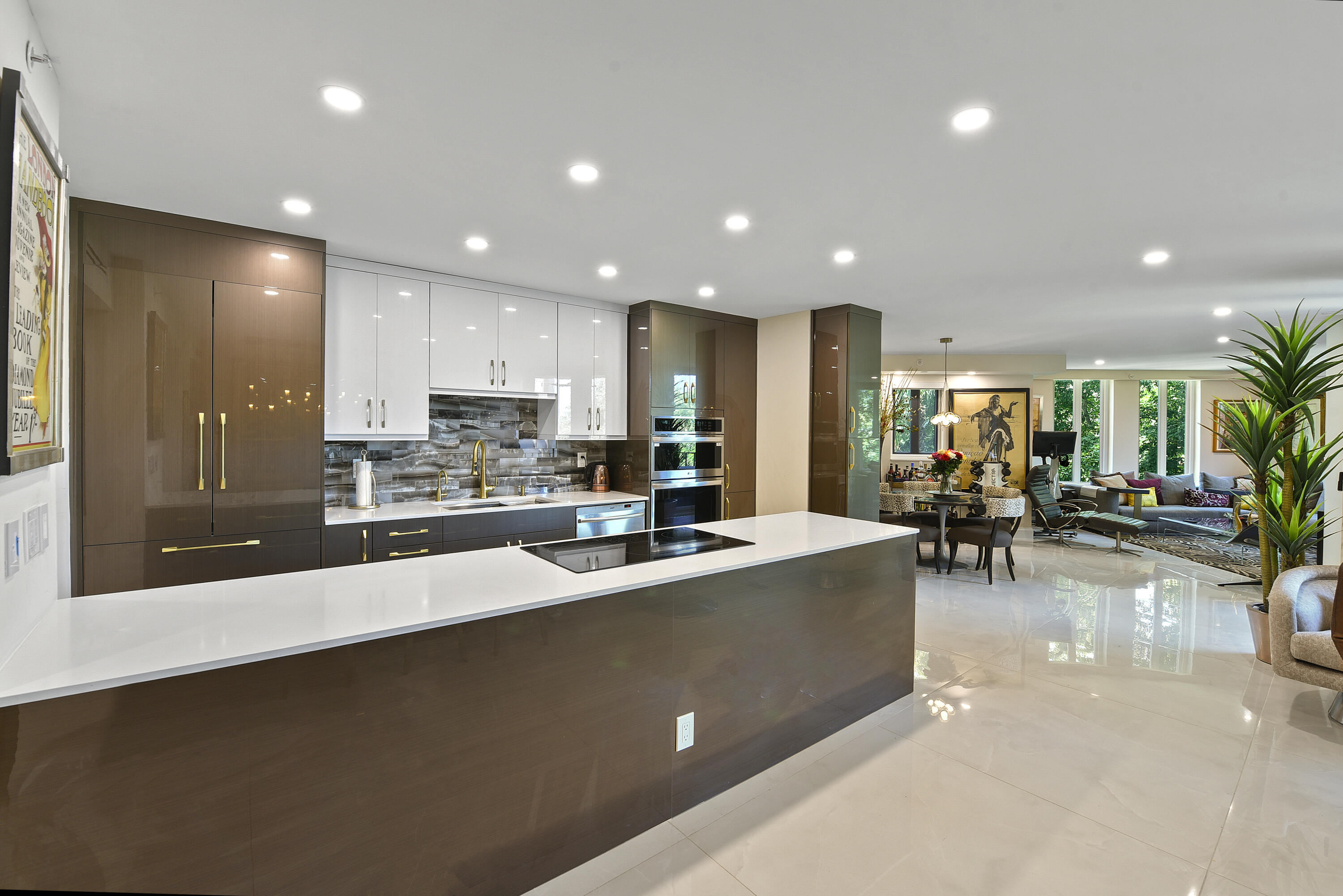 a view of a kitchen with kitchen island white cabinets and stainless steel appliances