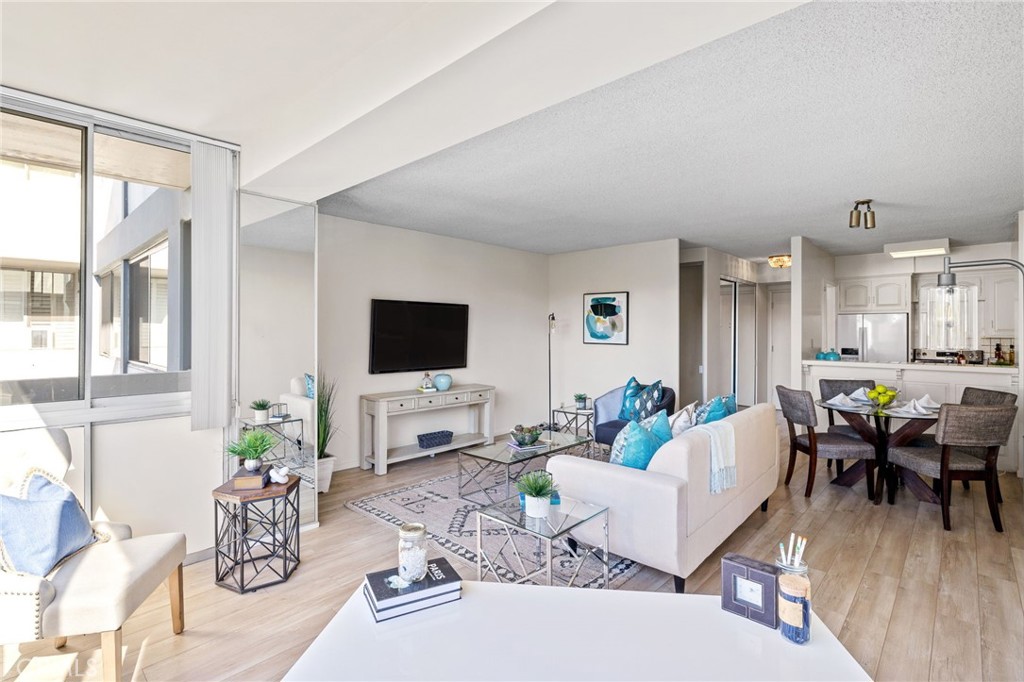 a living room with furniture a flat screen tv and a large window