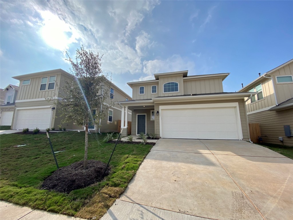 a view of a grey house with a yard