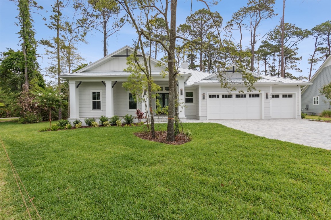 a front view of a house with a yard and trees