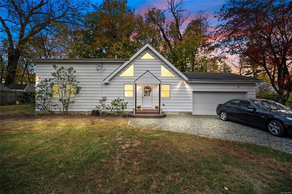 View of front of home featuring a garage and a yard