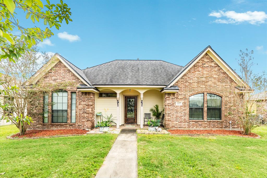 a front view of a house with a garden and yard