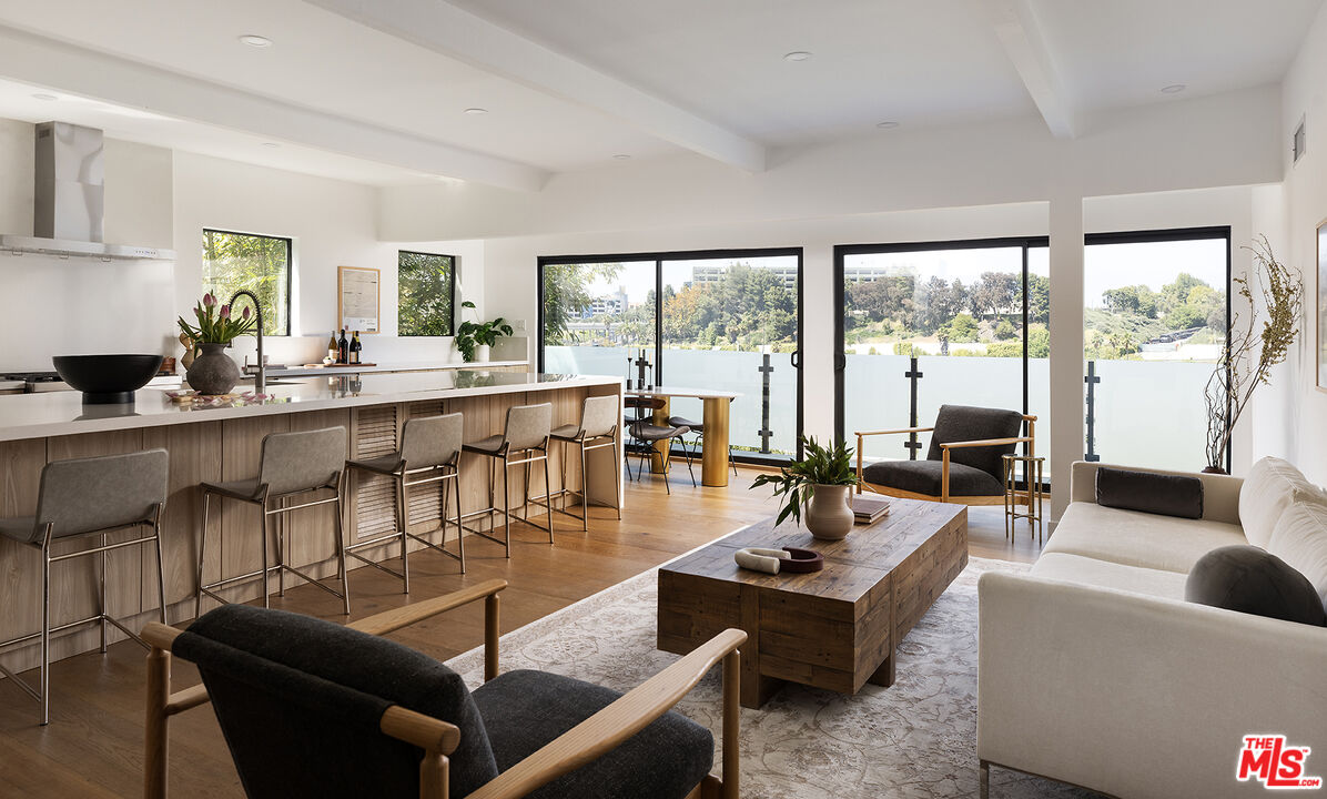 a living room with furniture and floor to ceiling windows