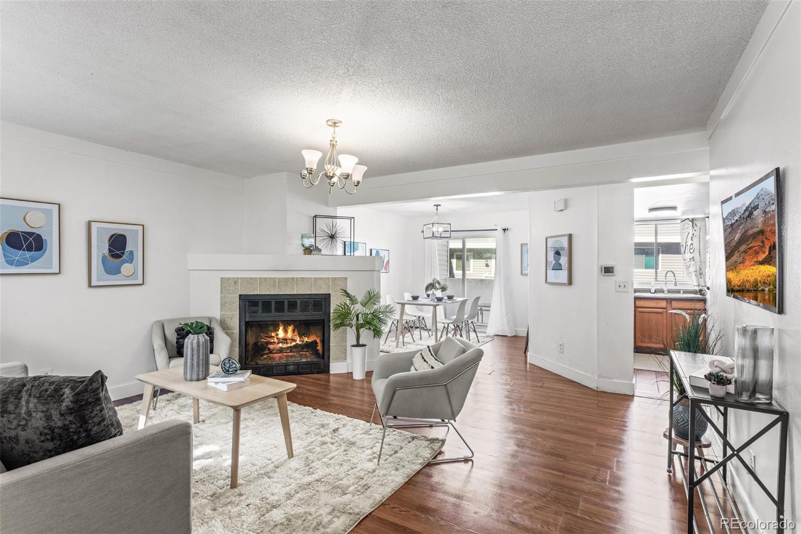 a living room with furniture a fireplace and a flat screen tv