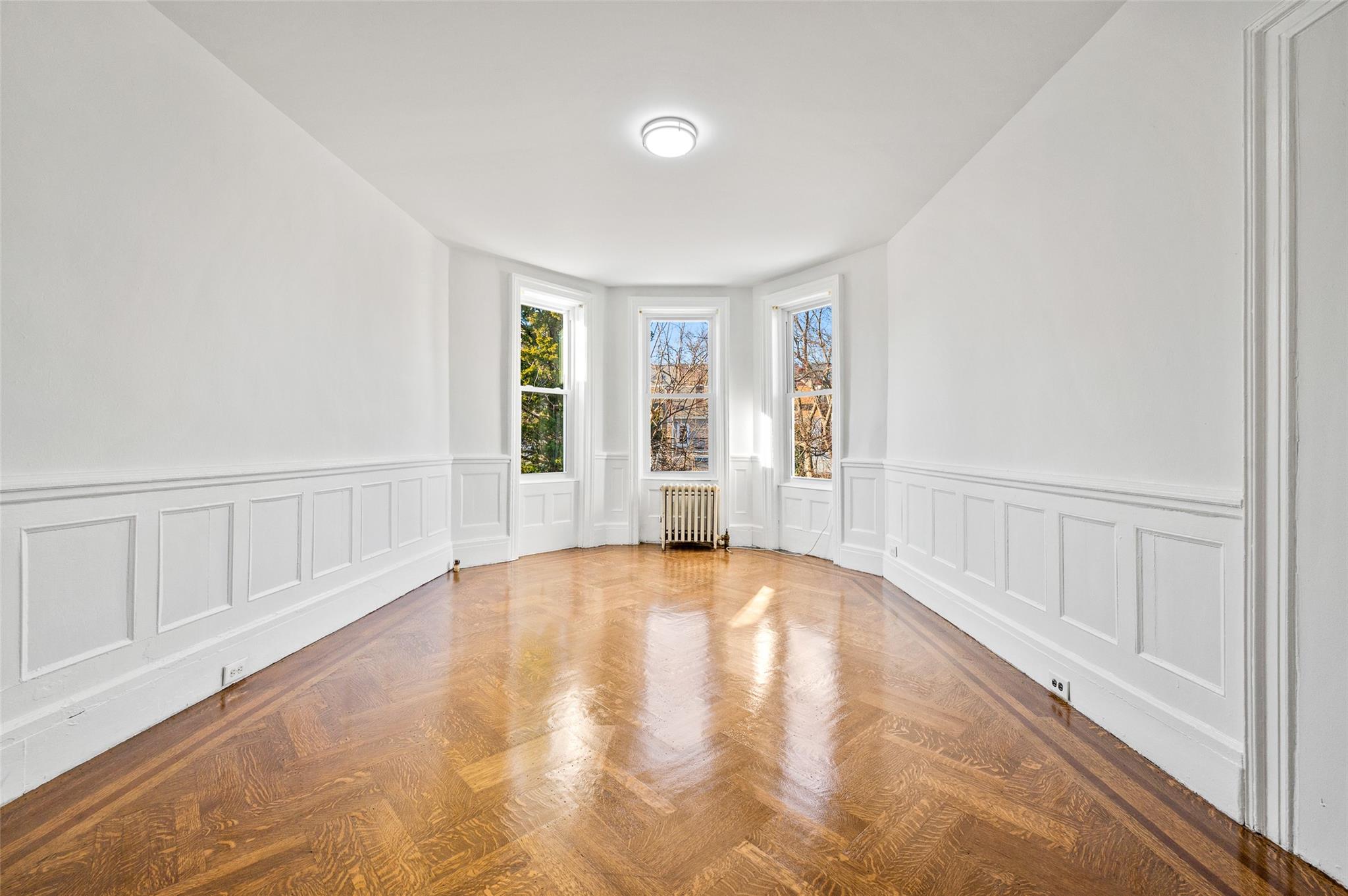 Spare room with radiator heating unit and parquet flooring