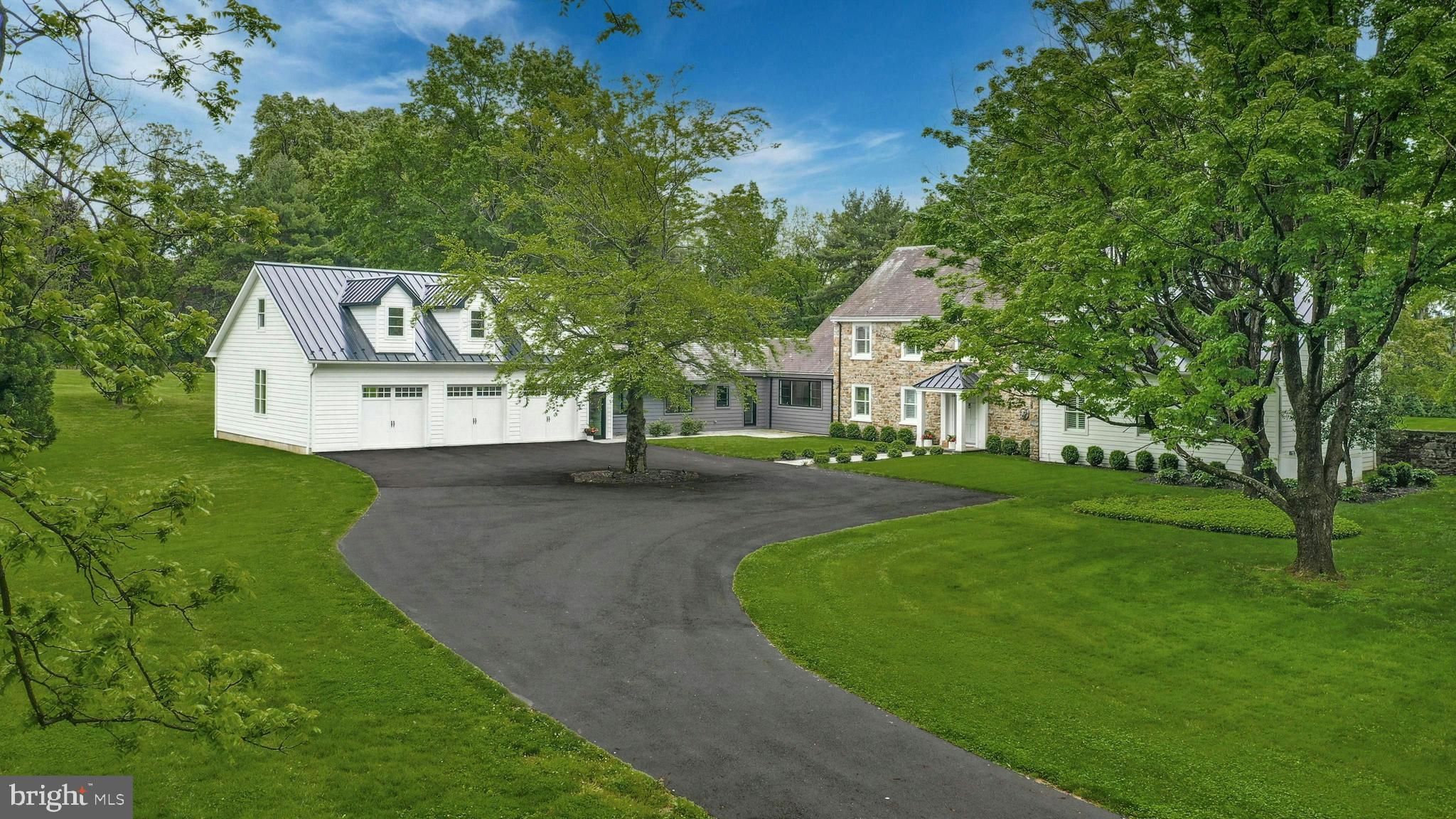 a front view of a house with a yard and tree s