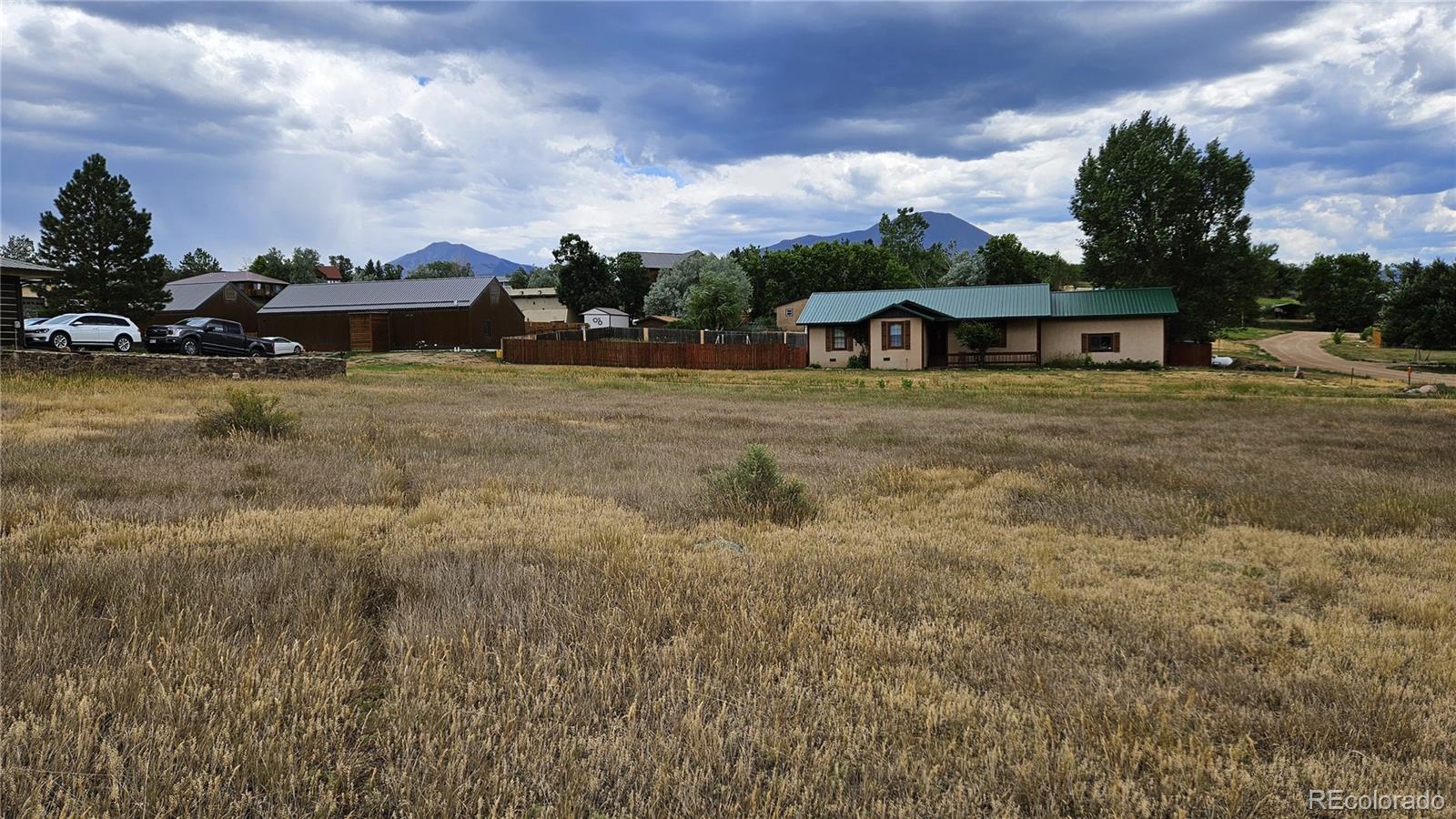 a view of a big house with a big yard and large trees