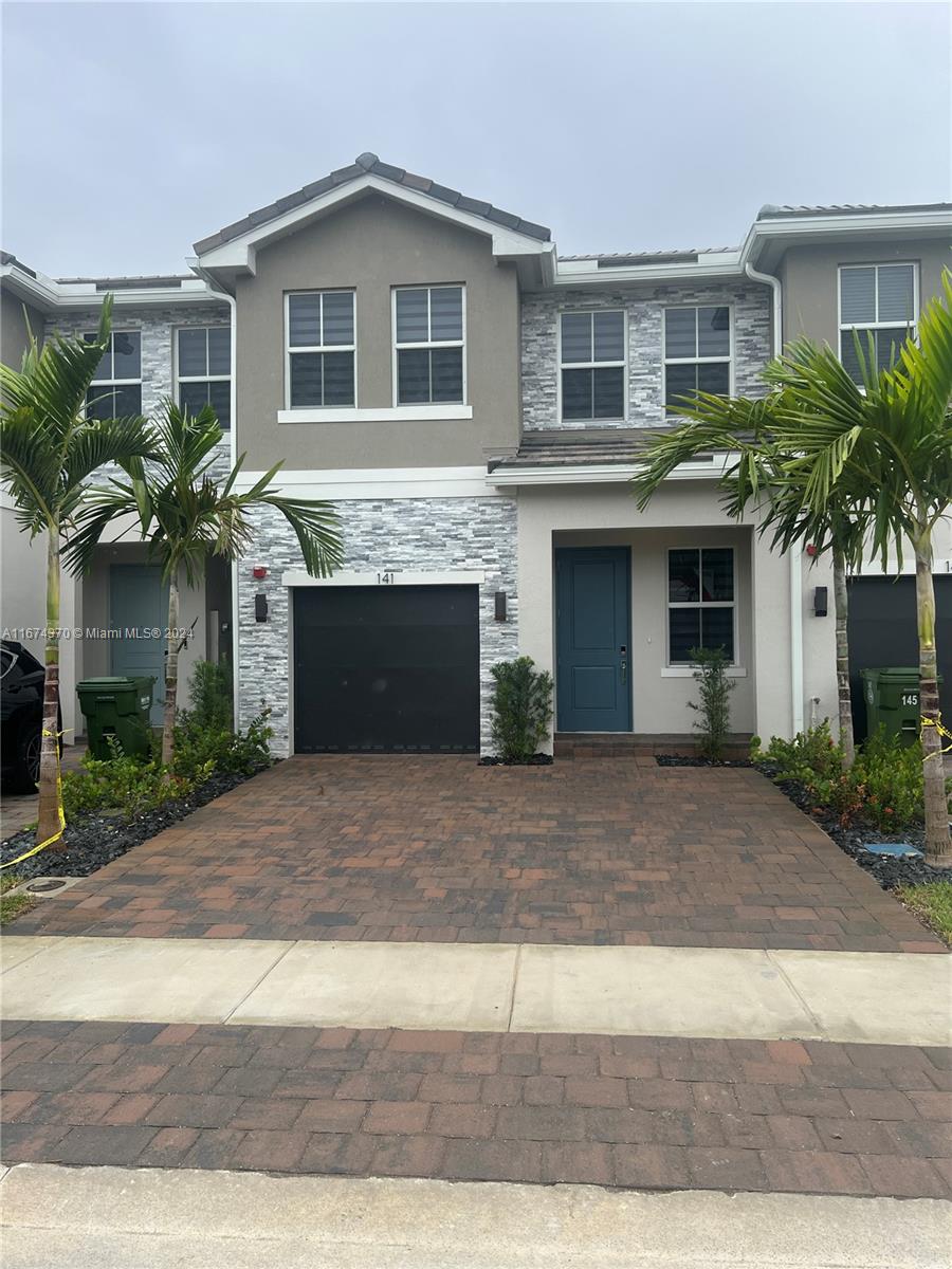 a front view of a house with a yard and a garage