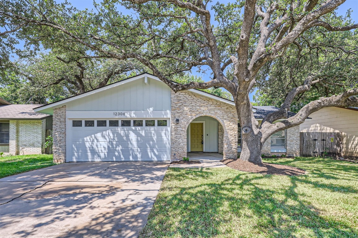 a front view of house with yard and trees around