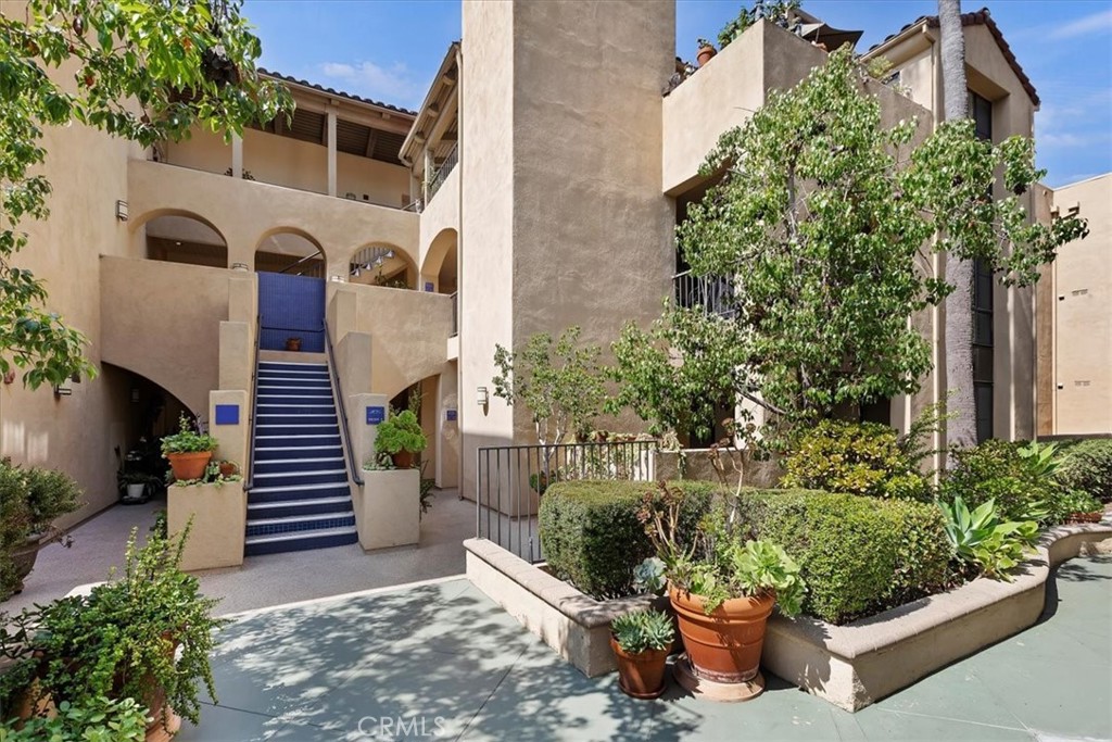 a front view of a house with a yard and potted plants