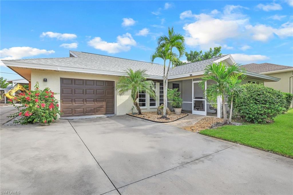 a view of a house with potted plants and a garage