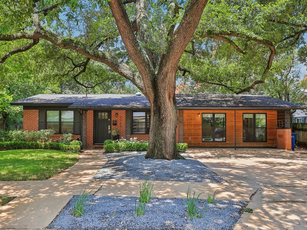 a front view of a house with a yard and potted plants