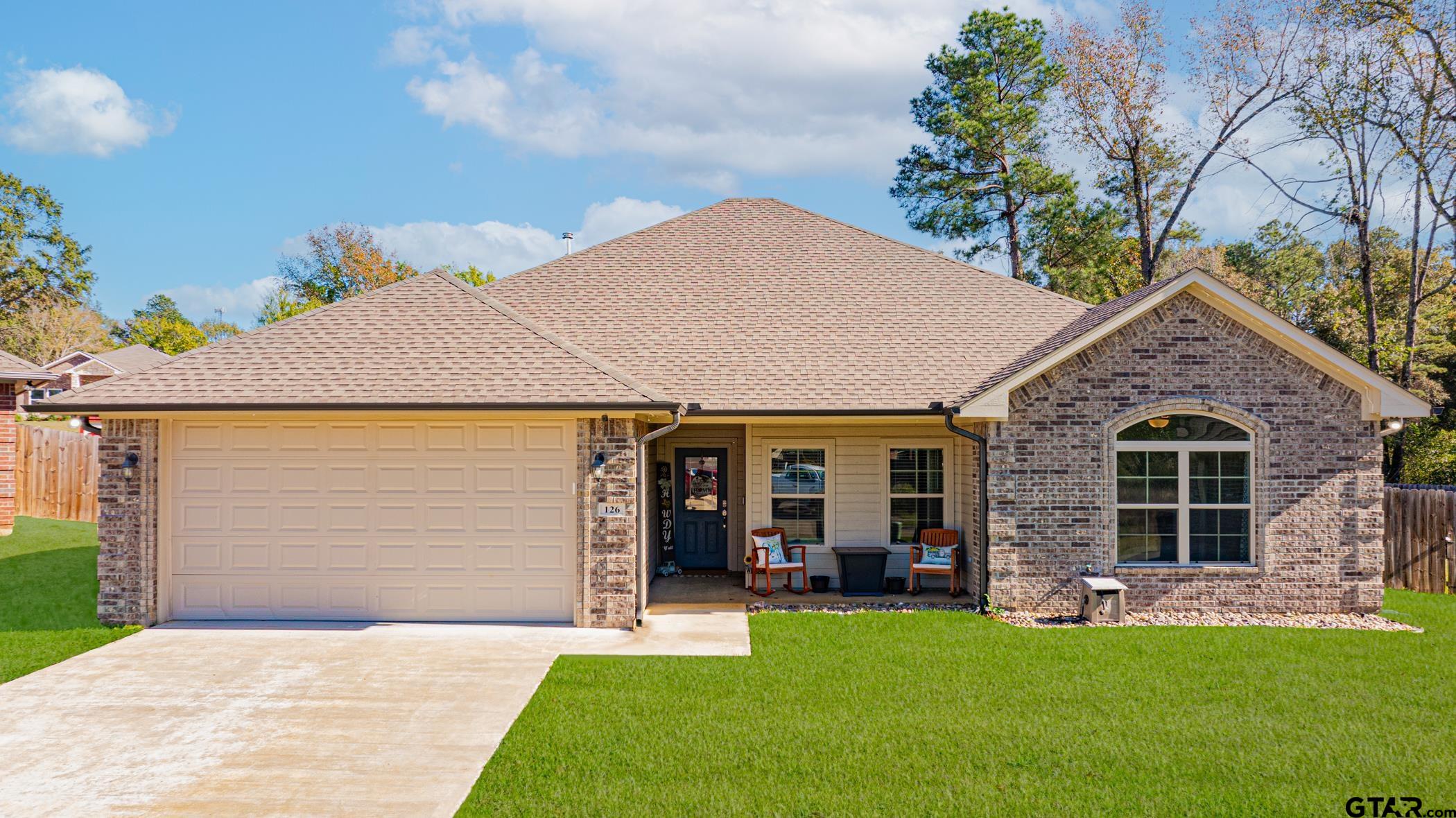 a front view of a house with a garden and yard