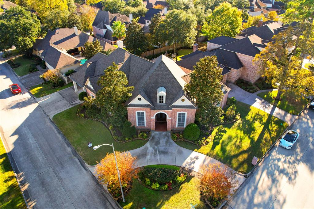 an aerial view of a house with a yard and large trees