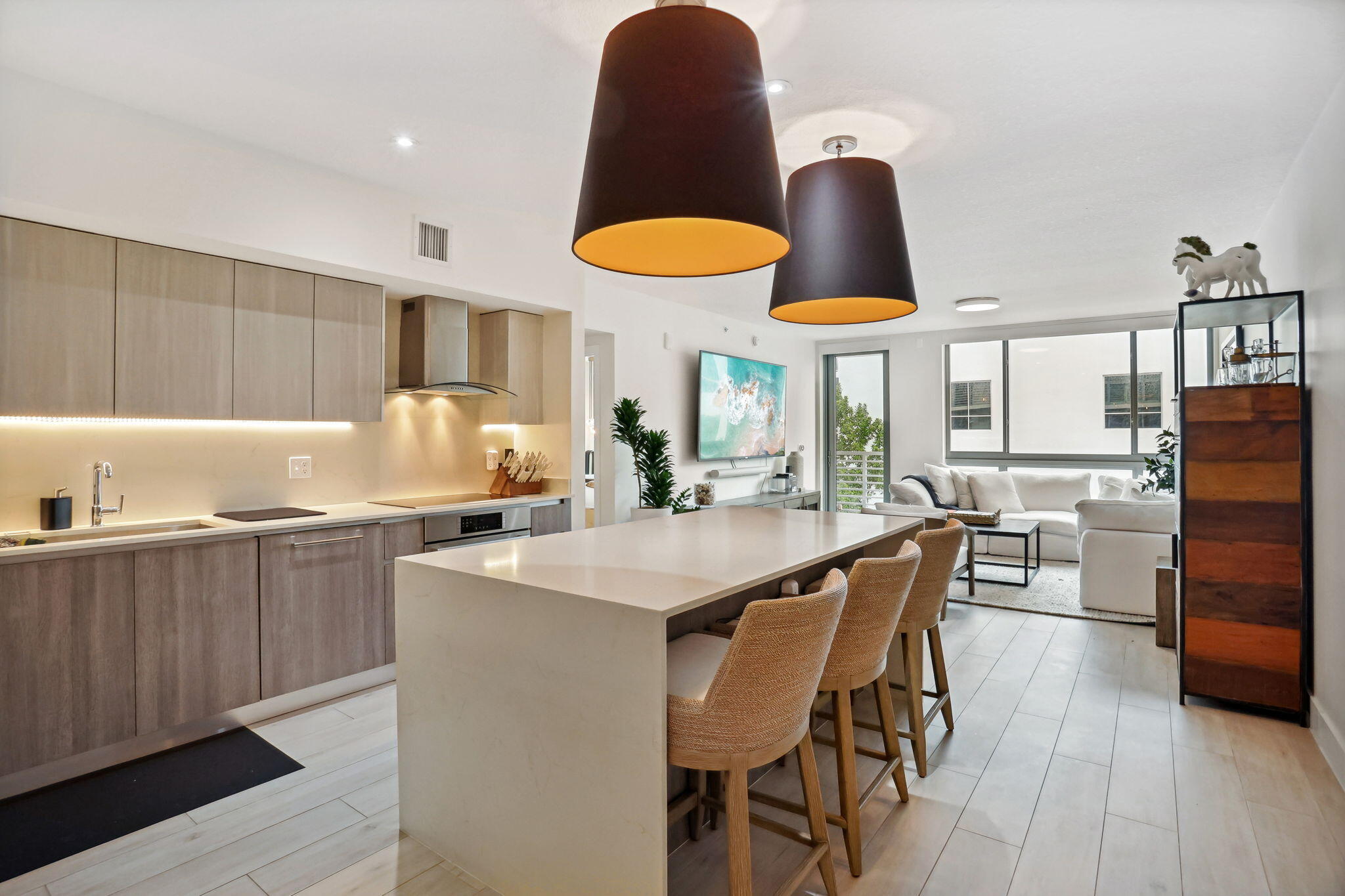 a kitchen with stainless steel appliances granite countertop a dining table chairs and white cabinets