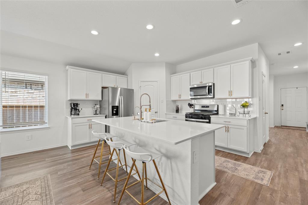 a kitchen with white cabinets and stainless steel appliances