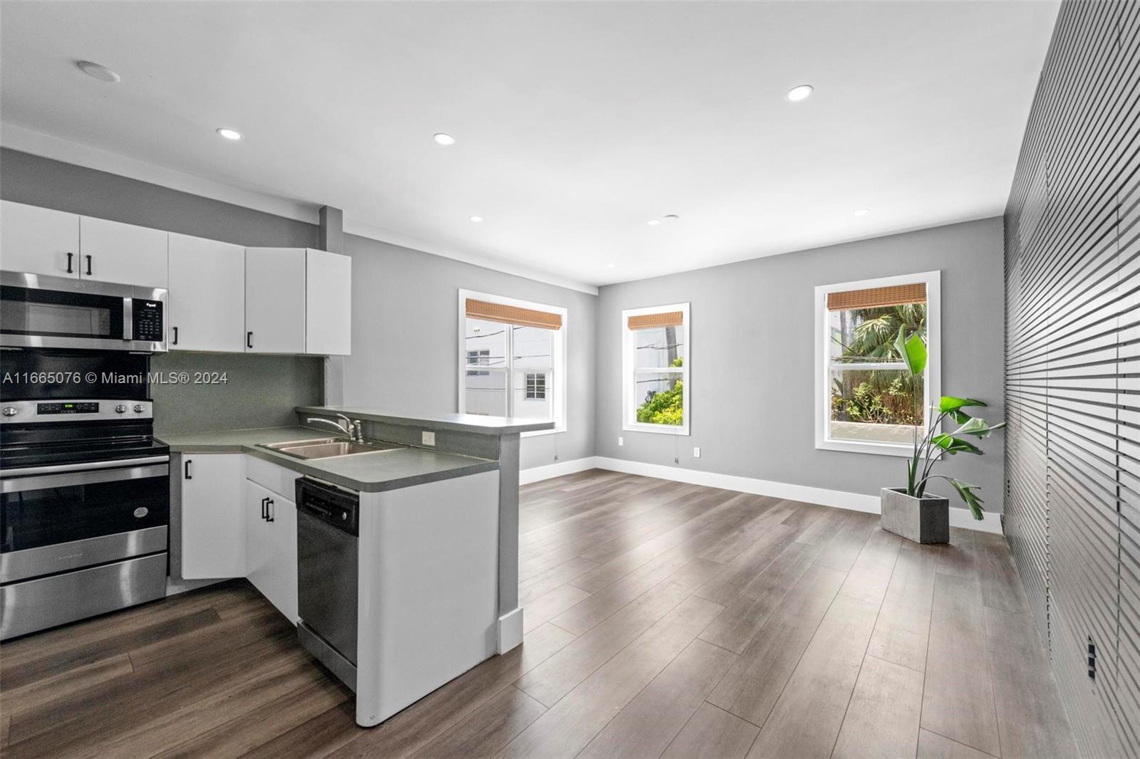 a kitchen with a stove a sink and wooden floor