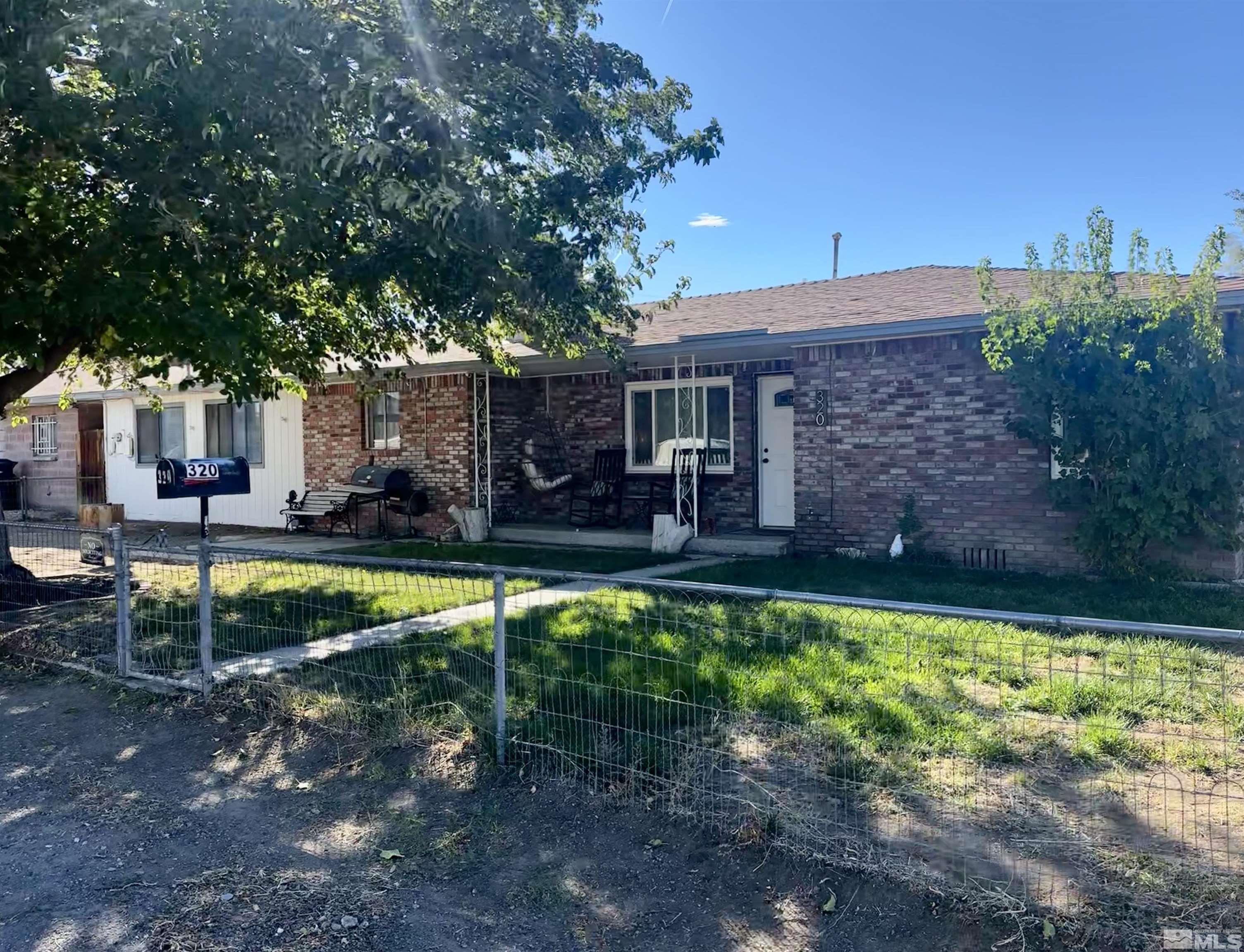 a view of a house with backyard and sitting area