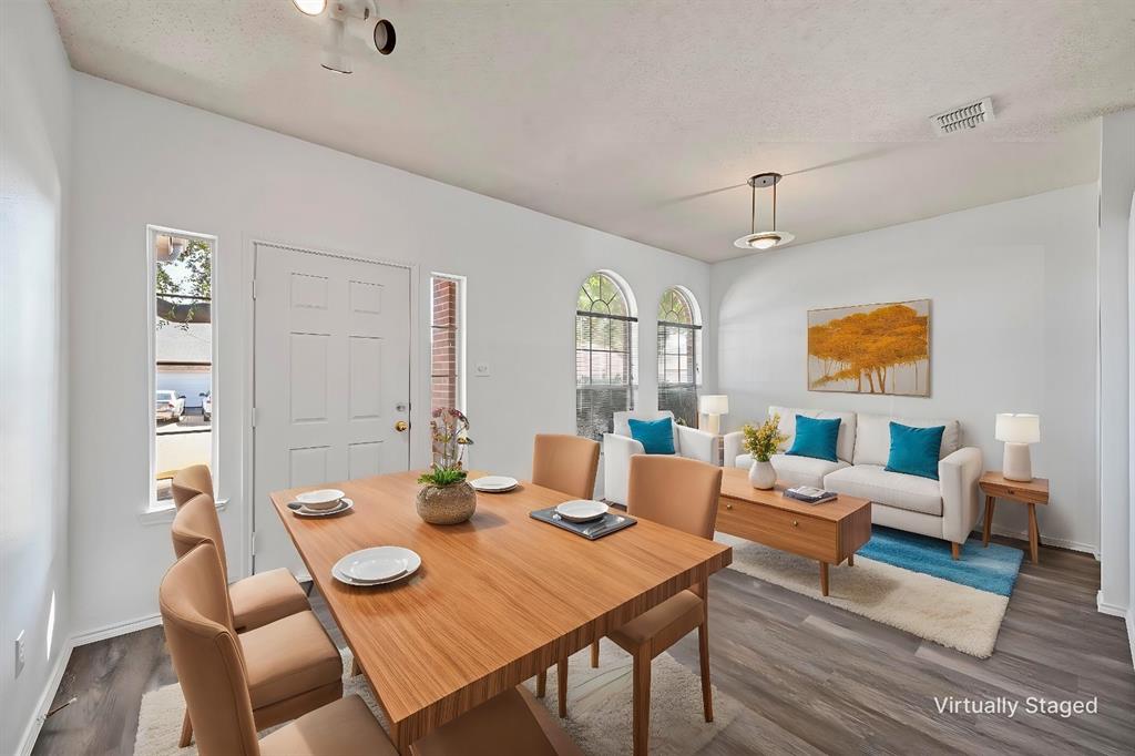 a view of a dining room with furniture a rug and wooden floor